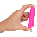 En hånd holder en liten, knallrosa klitorisvibrator i Soft Touch-silikon.