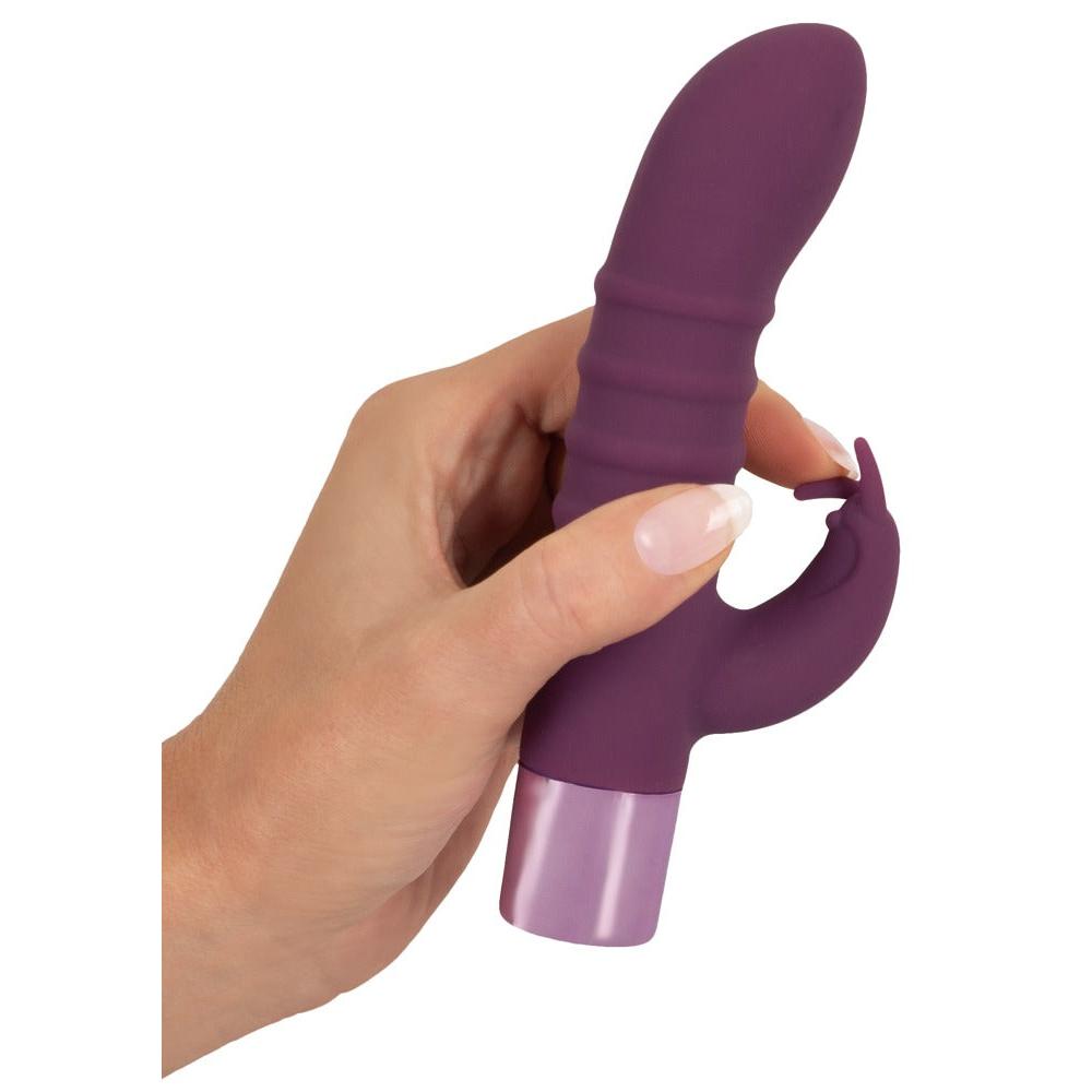 Hånd holder en lilla Rabbit Vibe vibrator i silkemykt silikon med metallisk base.