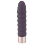 Elegant lilla klitorisvibrator med bølgeformet silikonoverflate og gullfarget metallbase.