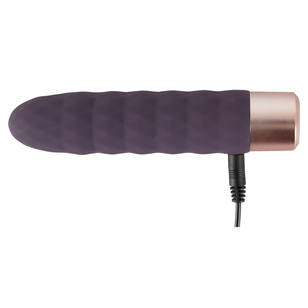 Elegant lilla klitorisvibrator i silikon med bølgeformet design og rosegull base, med ladekabel.