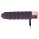 Elegant lilla klitorisvibrator i silikon med bølgeformet design og rosegull base, med ladekabel.