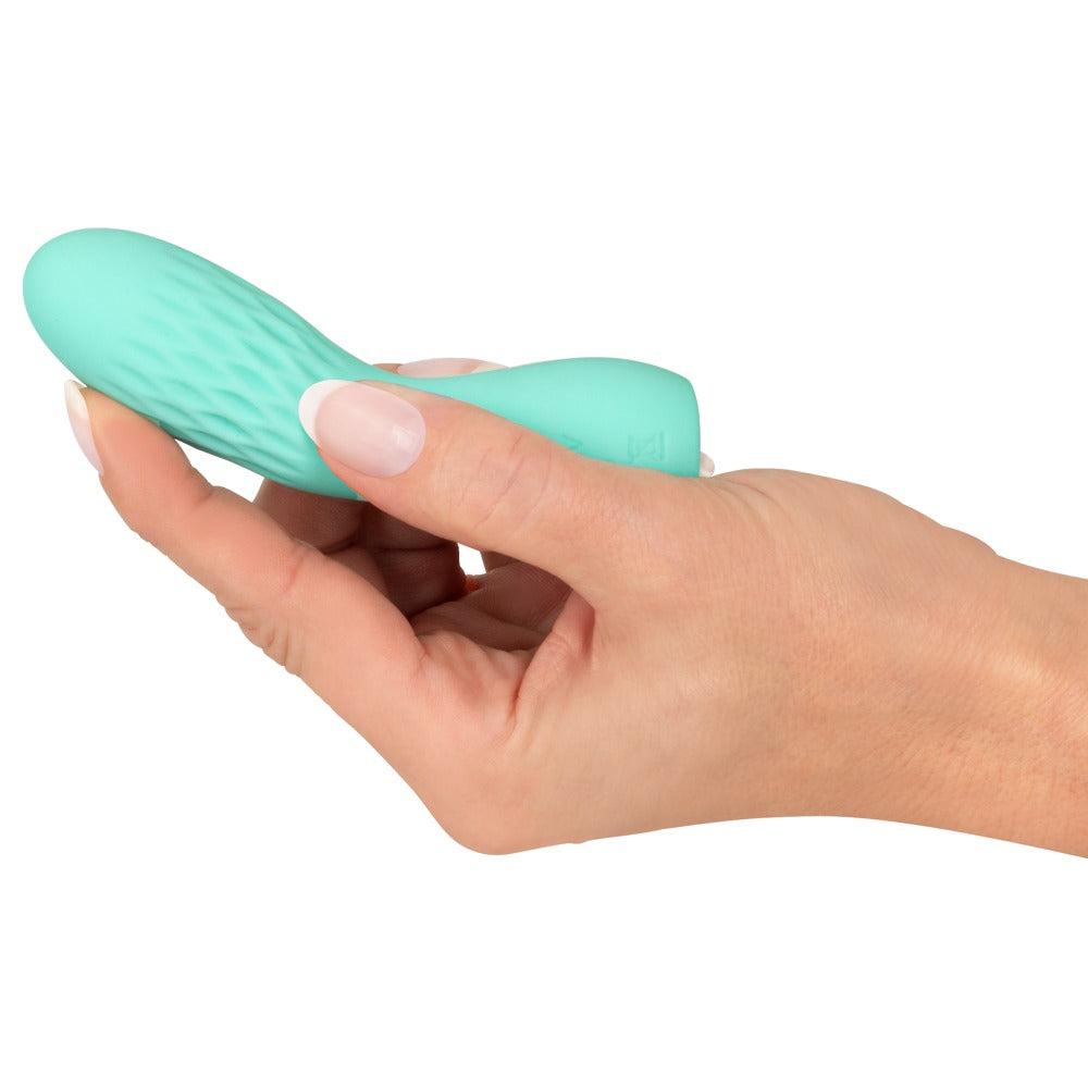 Turkis silikon minivibrator med rillet overflate, holdt i en hånd.