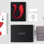 Rød, S-formet SVAKOM Phoenix Neo 2 parvibrator, eske, ladekabel, manual og oppbevaringspose.