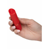 Hånd holder en rød Kyst Flicker klitorisvibrator i fløyelsmyk silikon med tungefunksjon og gullring.