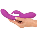 Javida Thumping Rabbit Vibrator i lilla silikon, holdt i en hånd, med buet tupp og klitorisstimulator.