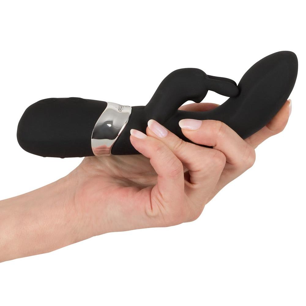Svart silikon rabbitvibrator med buet kropp og fleksible ører, holdt i en hånd.