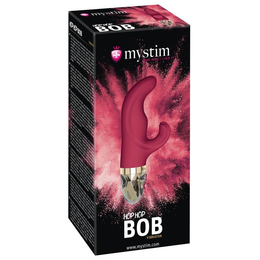 Mørk rosa silikon rabbitvibrator med gullfarget base og krystall-lignende tupp, vist i emballasje.