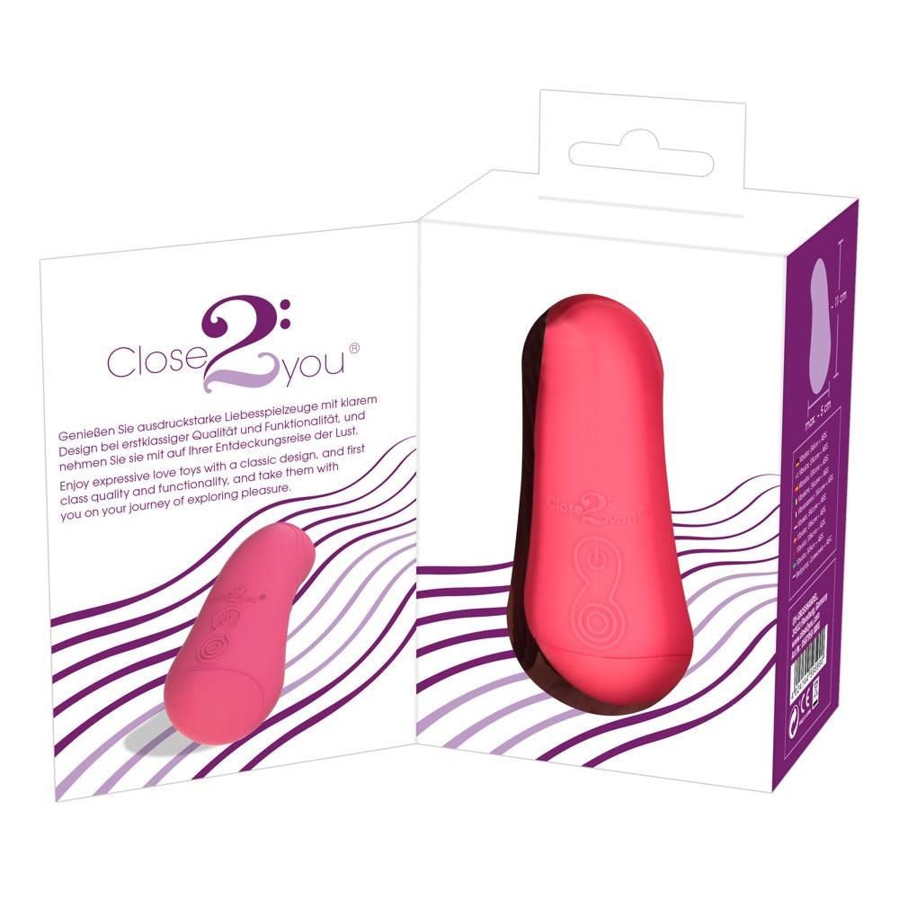 Corallino klitorisvibrator i matt rosa silikon, vist i og utenfor hvit emballasje.