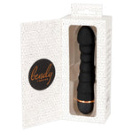 Svart silikon Bendy Ripple vibrator med penisformet tupp og 5 pirrebølger, delvis synlig i hvit eske.