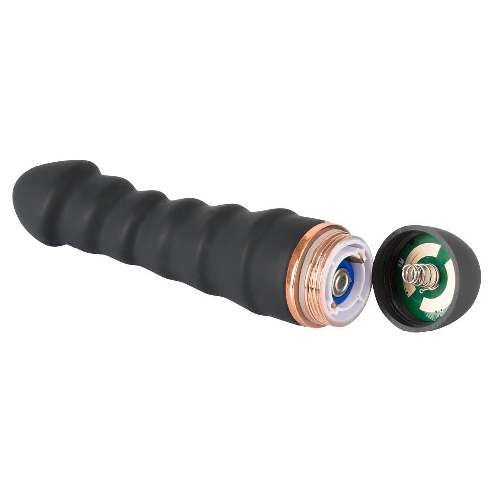 Svart silikon vibrator med 5 bølger, åpent batterirom med kobberdetaljer og avskrudd endestykke.