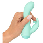 Hånd holder en mintgrønn Cuties Little Rabbit vibrator i silkemyk silikon med dobbel stimulering.