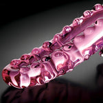 Rosa glassdildo, Icicles No. 24, med nupper og stimulerende riller på en mørk bakgrunn.