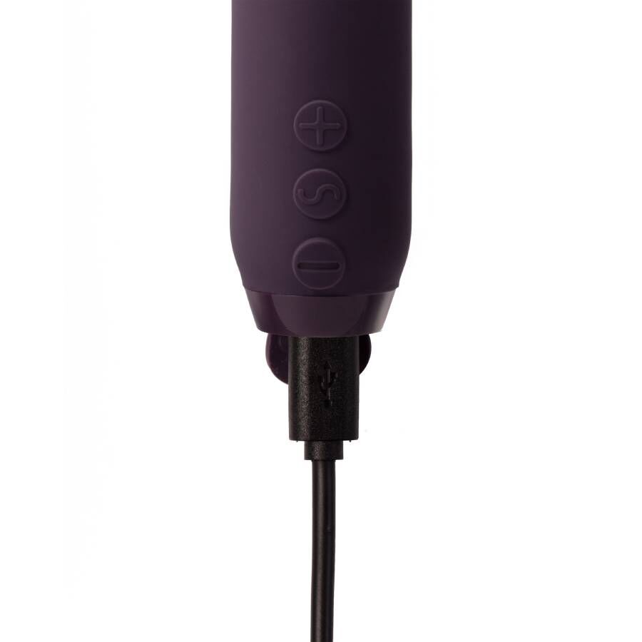Nærbilde av en lilla Je Joue Duet bullet vibrator i medisinsk silikon, med USB-ladekabel tilkoblet.