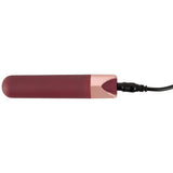 Mørkerød bullet-vibrator med rosegull-detaljer og ladekabel tilkoblet.