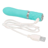 Turkis silikon vibrator med sølvdetaljer og diamantmønster, koblet til hvit USB-ladekabel.