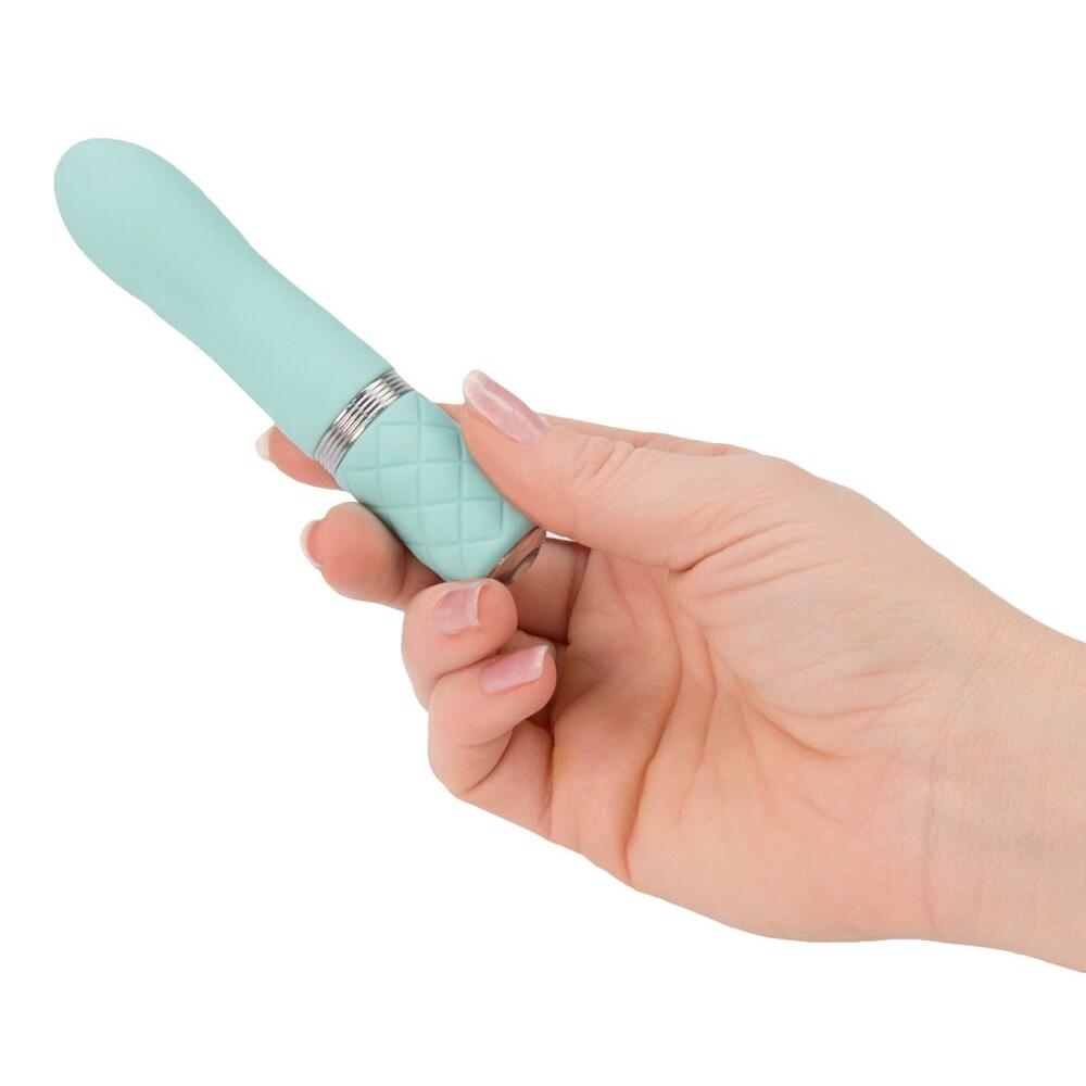 Mintgrønn silikonvibrator med riller og sølvdetaljer, holdt i en hånd.