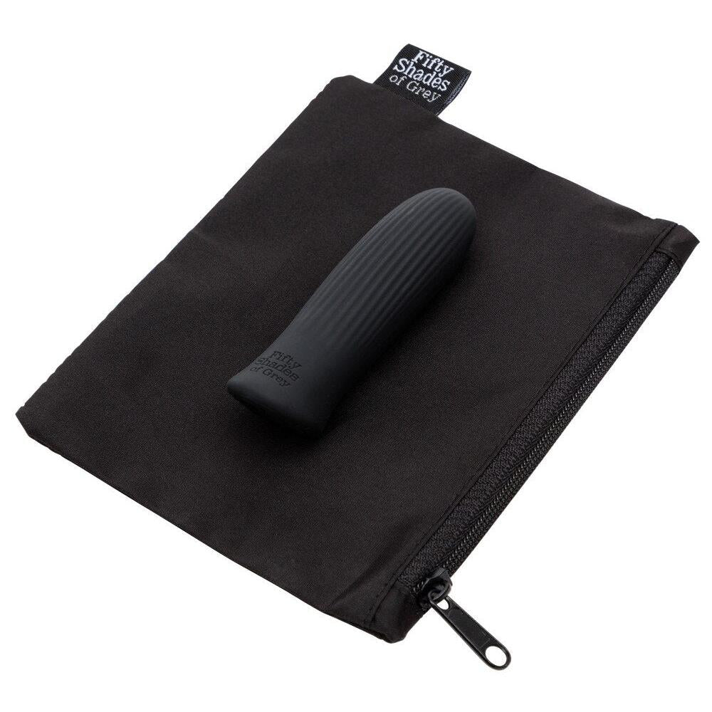 Svart Sensation Bullet Vibrator i silikon med riller, liggende på en åpen svart Fifty Shades of Grey oppbevaringspose.