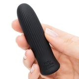 Svart, riflet silikon bulletvibrator fra Fifty Shades of Grey, holdt i en hånd.