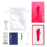 Rød We-Vibe Tango X klitorisstimulator, USB-kabel, satengpose, og eske med manualer.