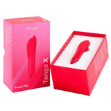 Rød We-Vibe Tango X klitorisstimulator i silikon, vist ved siden av sin rosa og røde emballasje.