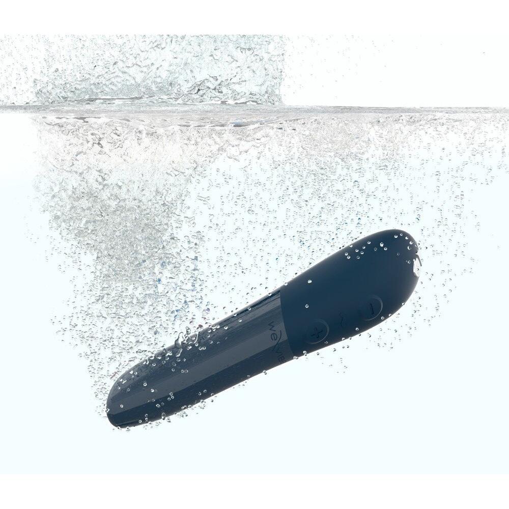 We-Vibe Tango X blå klitorisvibrator i silikon, delvis nedsenket i vann med bobler.