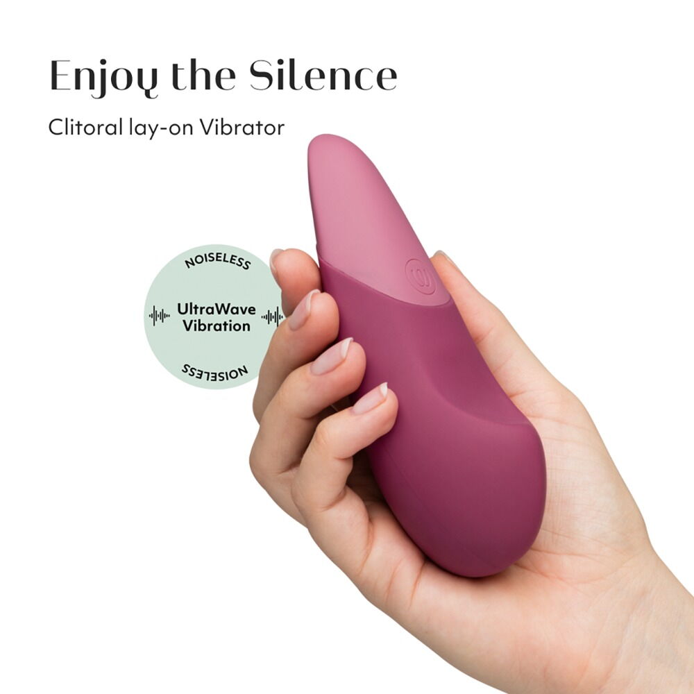 Mørk rosa Womanizer VIBE klitorisstimulator i silikon, holdt i en hånd.