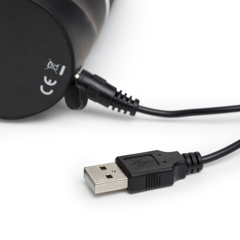 Svart HappyRabbit realistisk vibrator med USB-ladekabel tilkoblet, klar for lading.