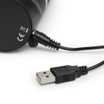Svart HappyRabbit realistisk vibrator med USB-ladekabel tilkoblet, klar for lading.