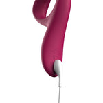 We-Vibe Nova 2 rabbitvibrator i mørk rosa silikon, med hvit ladekabel tilkoblet.