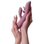 Trysta Neo rabbitvibrator i silkemyk lilla silikon, holdt i to hender.