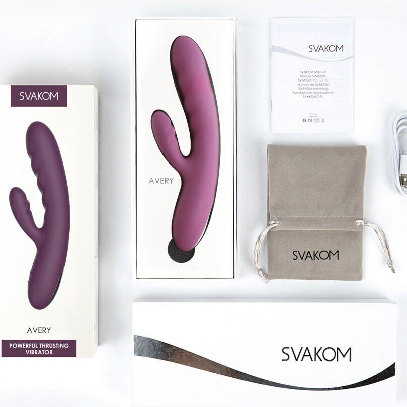 Dyp lilla Avery rabbitvibrator fra SVAKOM, i og utenfor esken, med ladeledning og oppbevaringspose.