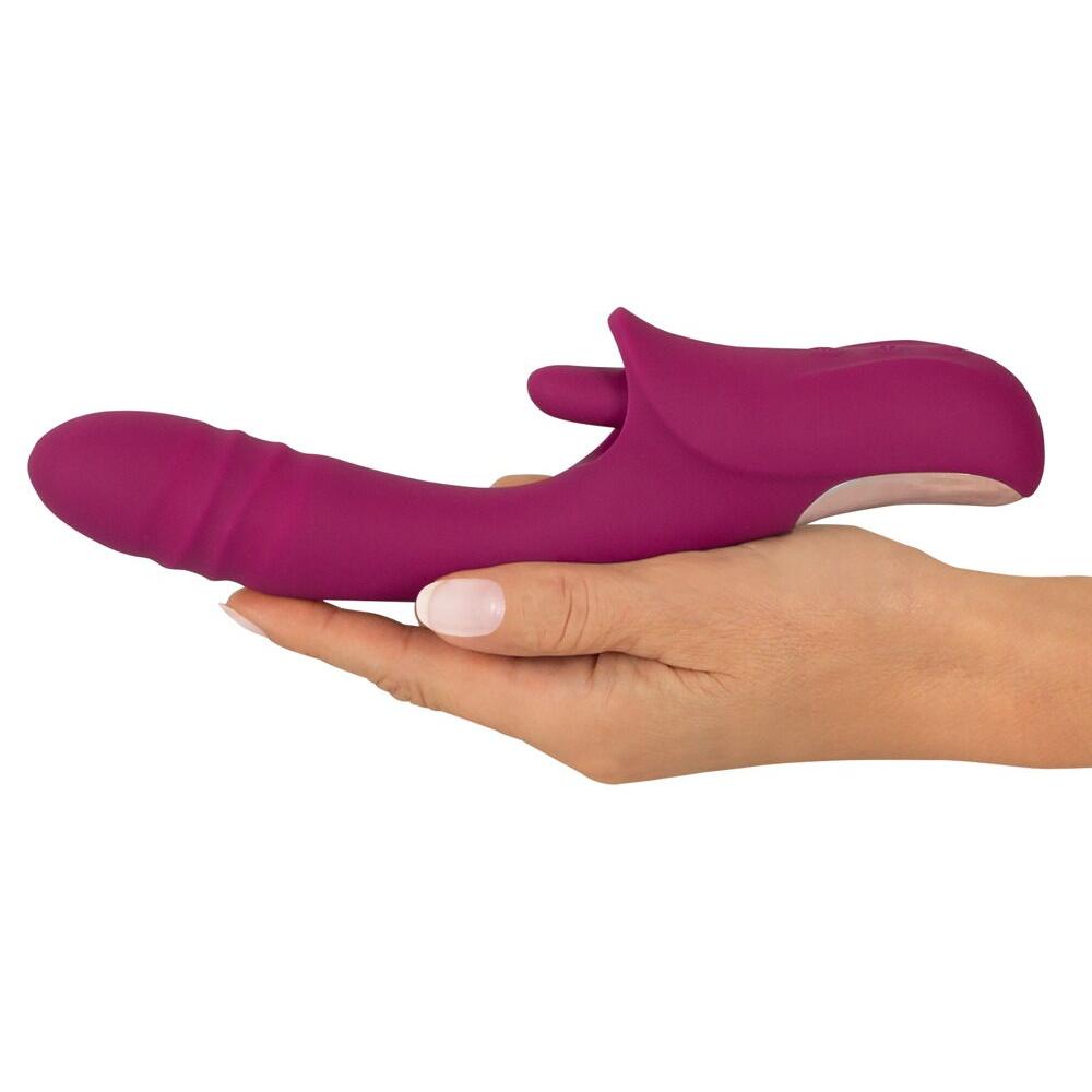 Javida Slikkende Rabbitvibrator i lilla silikon med støtfunksjon, holdt i en hånd.