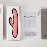 Mora Neo rabbitvibrator i rosa silikon, med emballasje, manual, ladekabel og grå oppbevaringspose.