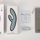 Chika Rabbitvibrator i lysegrønn silikon med varmefunksjon, eske, manual, ladekabel og pose.
