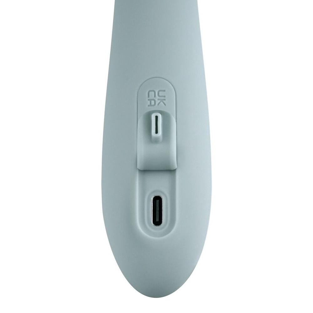 Lyseblå silikon rabbitvibrator med USB-C ladeport og kontrollknapp, detaljert nærbilde.