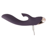 Mørk lilla silikon klitorissuger og G-punktvibrator med buet skaft og gullfarget tupp, koblet til ladekabel.