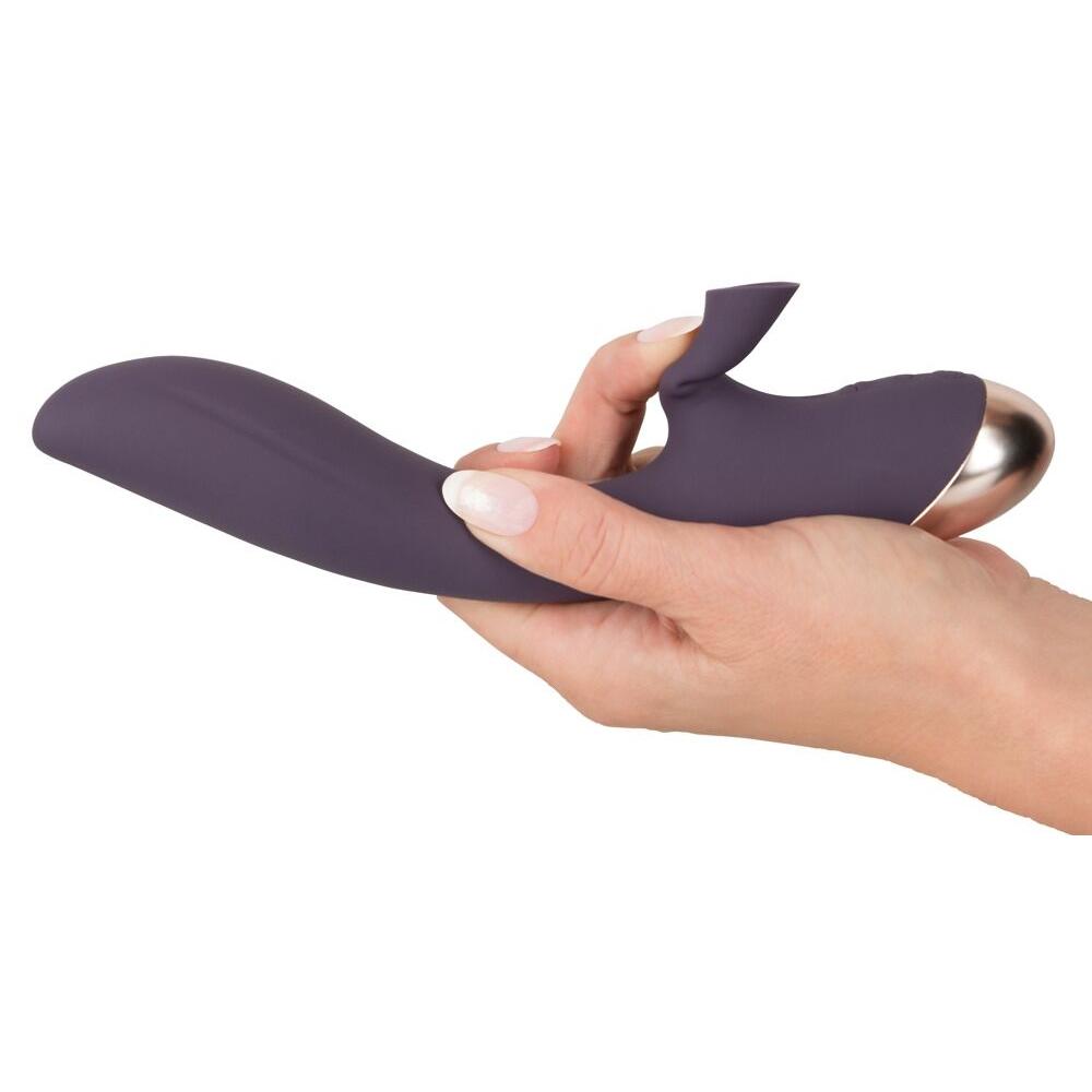 Lilla silikon klitorissuger og G-punktvibrator med gullfarget base, holdt i en hånd.