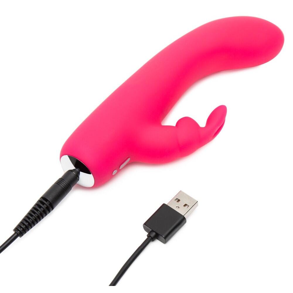 HappyRabbit Mini Rabbitvibrator i rosa silikon med buet tupp og kaninører, koblet til USB-ladekabel.
