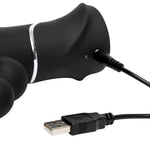 Svart silikon HappyRabbit Triple Curve vibrator med USB-ladekabel tilkoblet.