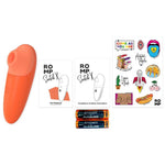 Oransje ROMP Switch X sugevibrator, to manualer, klistremerker og to AA-batterier.