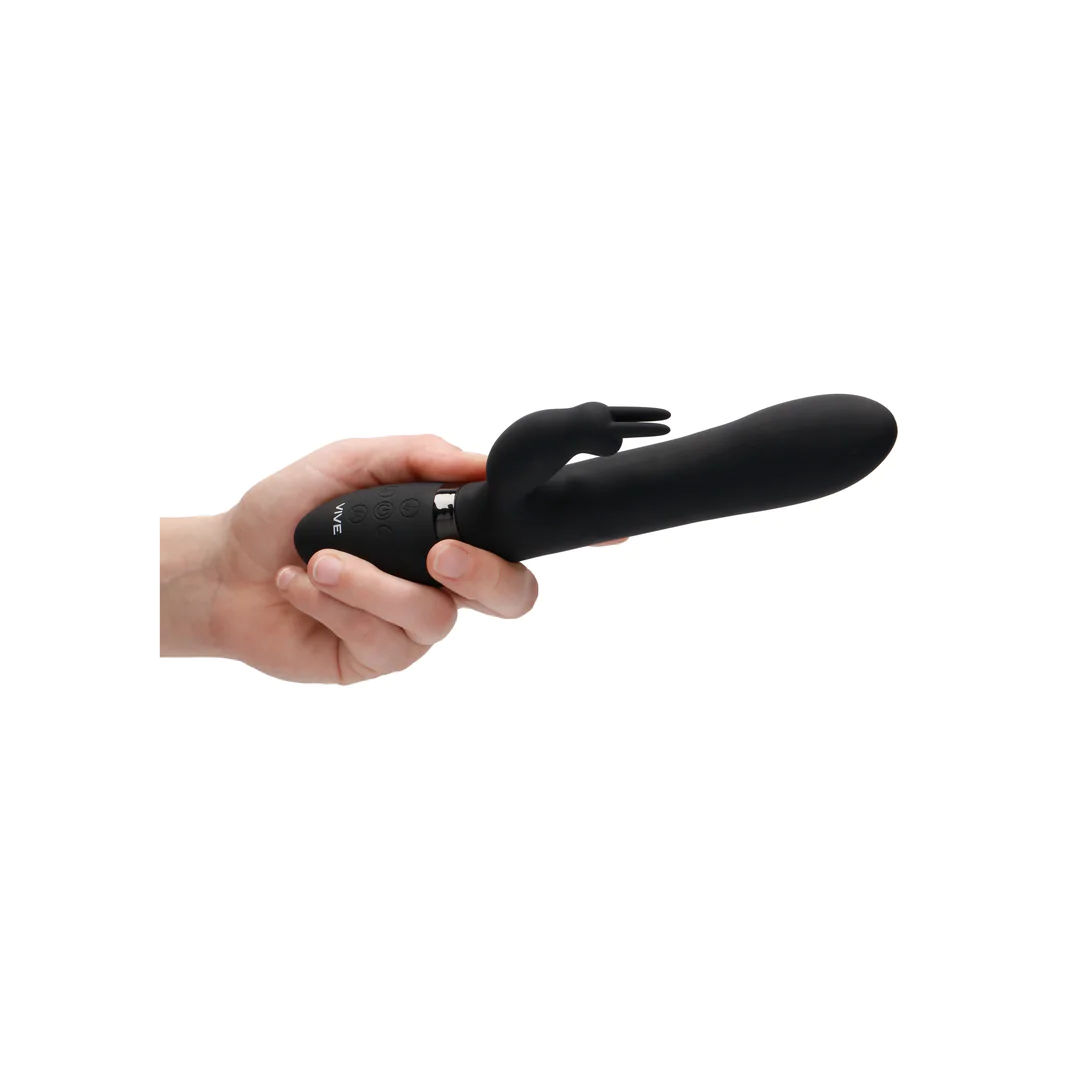 Hånd holder svart Amoris rabbitvibrator i medisinsk silikon med G-punkt og klitorisstimulator.