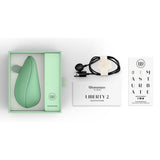 Womanizer Liberty 2 sugevibrator i myk mintgrønn, med USB-lader og instruksjoner i åpen eske.