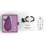Womanizer Liberty 2 i lilla, med ladeledning, hurtigstartguide og eske.