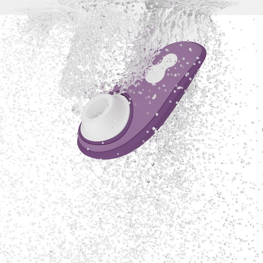 Womanizer Liberty 2 i lilla med hvit stimulator, nedsenket i vann.