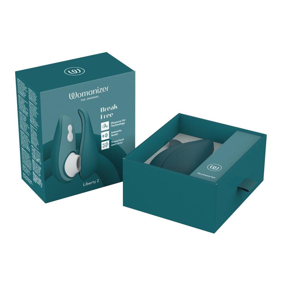 Mørkegrønn Womanizer Liberty 2 sugevibrator i åpen eske med magnetdeksel og tilbehør.