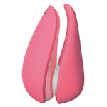 Womanizer Liberty 2 i korallrosa, en kompakt sugevibrator med magnetdeksel og hvit tupp.
