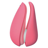 Womanizer Liberty 2 i korallrosa, en kompakt sugevibrator med magnetdeksel og hvit tupp.