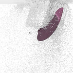 Womanizer NEXT sugevibrator i elegant lilla med Soft Touch-overflate, nedsenket i vann.