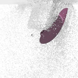 Womanizer NEXT sugevibrator i elegant lilla med Soft Touch-overflate, nedsenket i vann.