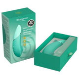 Mintgrønn Womanizer NEXT sugevibrator med slank design, vist i åpen og lukket eske.